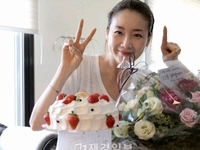 女優チェ・ジウが、韓国の人気バラエティー番組「1泊2日」の製作陣が送った誕生日ケーキと花束と共に写った写真を公開した。写真：チェ・ジウの公式ホームページ（starjiwoo.com）