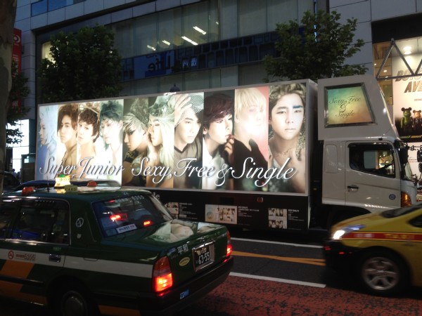 SUPER JUNIORの巨大バナー「sexy men's exhibition」が24日、渋谷駅で公開された。渋谷駅近辺ではSUPER JUNIORのプロモーショントラックの姿も見られた。（2012年8月24日渋谷駅付近にて）