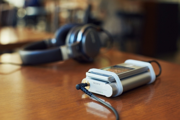 ウォークマンなど多様な携帯型音楽プレーヤーやスマートフォンと組み合わせて、高音質再生を楽しめる小型軽量のポータブルヘッドホンアンプ「PHA-1A」をウォークマン（R）に接続しているところ（写真提供：ソニー）