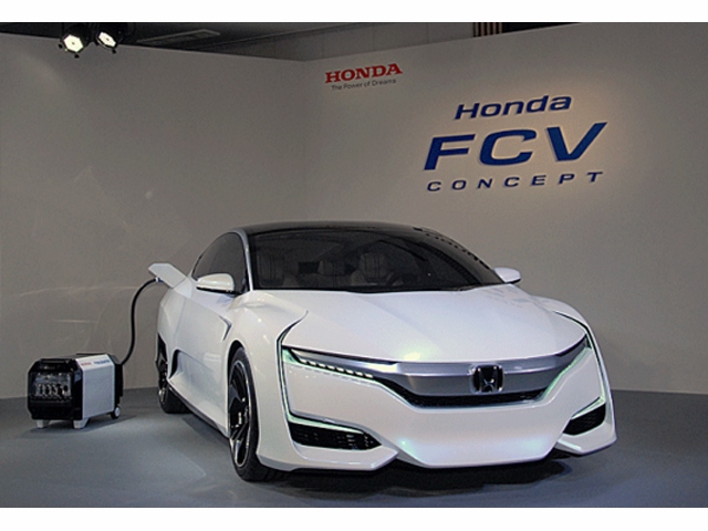 鳥取大学医学部附属病院とHondaは共同で、FCVやEVから最大出力9kWの電力を使用可能にする外部給電用インバータ「Power Exporter CONCEPT 9000」を用いた実証実験を行なう。濃縮酸素供給装置やポータブルX線装置などの医療機器へ給電、災害時などの総合的な医療活動への効果を検証する。写真左後方でFCVに接続しているのがPower Exporter