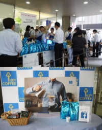 キーコーヒー＜２５９４＞（東１）は、１０月１日（木）に、新虎通り沿いにある同社本社ビル１階で第５回「コーヒーの日工場直送　チャリティーセール」を開催、１１：００の開始から多くのコーヒーファン中心に詰めかけ、本社前まで行列ができるほどの盛況さであった。