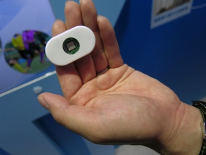 オムロンがCEATECの会場で公開した8.1mm×7.7mmセンサーチップを筐体中央に内蔵した「貼り付け型電子体温計」。小型通信システムと駆動用バッテリーを内蔵する