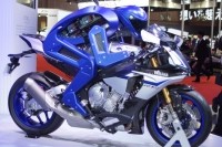 ヤマハのMoToGPマシン「YZF-R1M」にまたがる「MOTOBOT」。まだ体重移動はできないが、アクセル、ブレーキ、ギアチェンジはバイクの改造無しで操作可能。