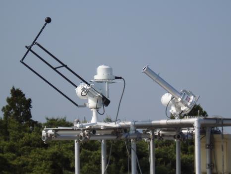 直達放射（右）と散乱放射（左）を測定している分光放射計。直達放射は筒をつけて太陽の方向からの日射だけを測定する。散乱放射は太陽の方向を黒い球で隠して測定する。いずれも、太陽追尾装置に取り付けられている。（九州大学の発表資料より）