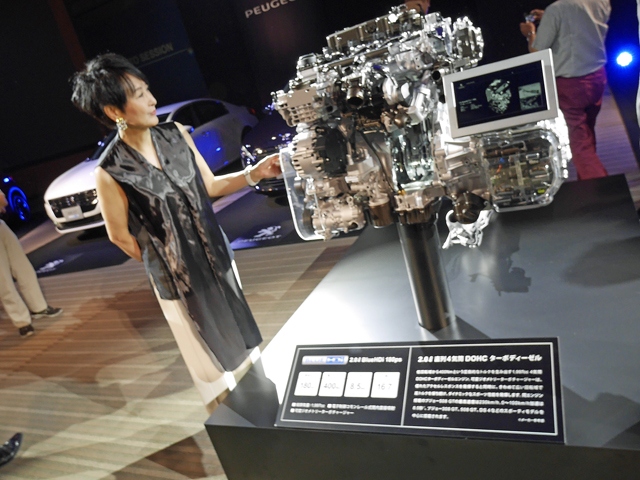 プジョー・シトロエン・ジャポンが、都内で「BlueHDi」ディーゼル搭載車を一挙に紹介した。おそらくPSAグループ合同の記者発表は日本で初めて。写真は2リッター「BlueHDi」ディーゼルと発表会の司会進行を担当したキャスター&アナウンサーの吉川美代子氏
