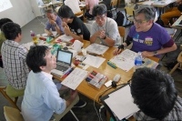プログラム後半。参加者はワークシートに各自の作品アイデアを書き込み、それぞれ即興でアイデアを発表する「アイデア・ワークショップ」の時間。数人のグループでテーブルを囲んで話し合いながら企画案を練り上げる