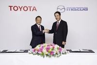 提携発表の記者会見で握手するトヨタの豊田社長(左)とマツダの小飼社長。(写真: トヨタ自動車の発表資料より)