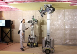積水ハウスとテムザックが開発中の天井石膏ボード施工ロボット「Carry」と「Shot」。施工技能者と協業して天井石膏ボードの張り付けを行う。