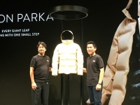 完成した「ムーン・パーカ」とゴールドウインの渡辺貴生副社長執行役員（左）とスパイバーの関山和秀代表