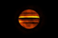 アルマ望遠鏡がとらえた木星の電波画像。明るい帯は、大気が下降する領域となる高温域、暗い帯は、大気が上昇する領域となる低温域を示す。(c) ALMA (ESO/NAOJ/NRAO), I de Pater et al.; NRAO/AUI NSF, S. Dagnello