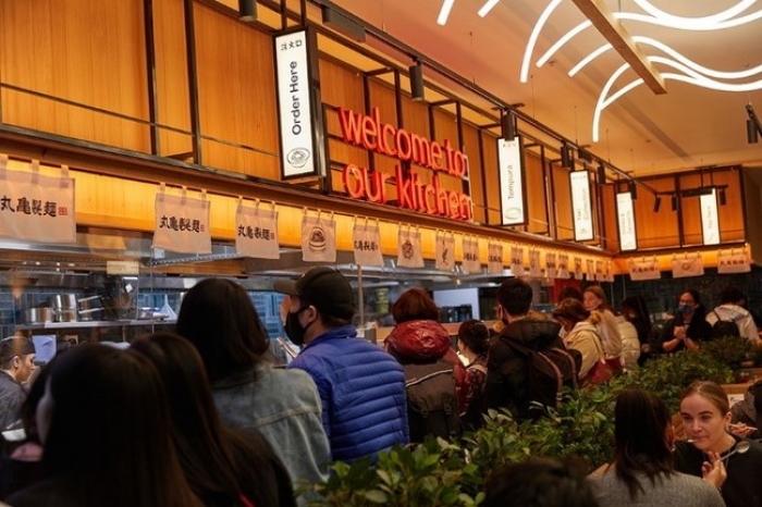 トリドールホールディングス＜３３９７＞（東１）は、２０２１年１０月２３日（土）に讃岐うどん専門店「丸亀製麺（現地名称：Ｍａｒｕｇａｍｅ　Ｕｄｏｎ）」のイギリス第２号店をグランドオープンした。グランドオープン当日は、待ち時間が９０分以上となり、１号店同様に大盛況での滑り出しとなった。