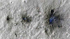2021年9月5日に隕石の衝突により火星にできたクレーター。インサイトによって初めて検出されたもの。撮影はNASAの衛星Mars Reconnaissance Orbiterにより行なわれ、衝突により散乱した塵や土を青色で示している (c) NASA/JPL-Caltech/University of Arizona