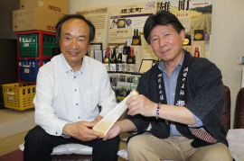 サクラ酵母で造った日本酒を手にする滝澤教授（左）と花房社長（右）