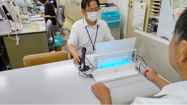 AI音声認識文字起こし支援アプリ「ScribeAssist」を活用　大分県中津市・福祉支援課で、会話を字幕表示するディスプレイの実証実験を開始