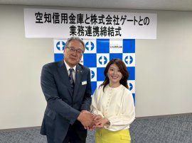 業務提携を締結し笑顔で握手を交わす国井代表取締役(右)と熊尾理事長