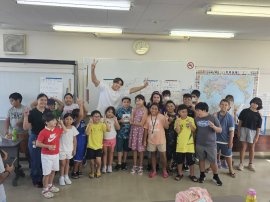 「日本語補修教室に通う子どもたちと笑顔で記念撮影する當間ローズ(湖西国際交流協会にて、2025年8月18日)」 「日本語補修教室に通う子どもたちと笑顔で記念撮影する當間ローズ(湖西国際交流協会にて、2025年8月18日)」