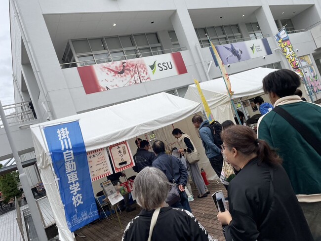 「街をつくる教習所」掛川自動車学校が静岡県内の大学の学園祭に出展　新キャラクター「かけまる」が学生に大人気！