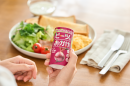 朝食のプレートを前にビーツのおかげを手に持つ様子 朝食のプレートを前にビーツのおかげを手に持つ様子