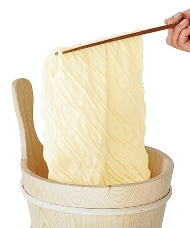 新生活を「まめ」に過ごせる2つの大豆商品がユーモアから新登場！リアルなしわを再現した「ゆばタオル」と、具材靴下を詰めた「油あげ巾着ソックス」。