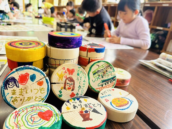 昭和レトロな温泉銭湯 玉川温泉が「母の日イベント」に向けて、学童保育の子供たちを訪問。地元間伐材のヒノキ入浴木にメッセージをもらいます